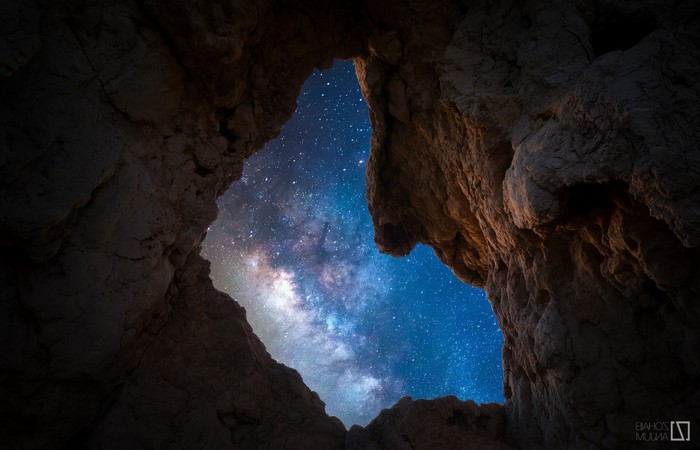 Cave opening revealing the Milky Way galaxy at night