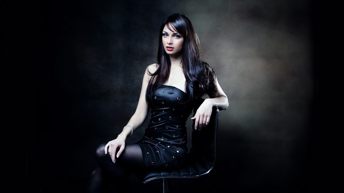 Woman in black dress sitting on a chair