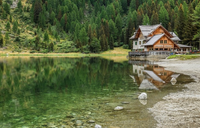 Cabin by a lake in a pine forest in Italy