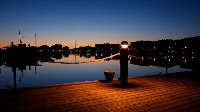 Dock at night with city skyline reflection