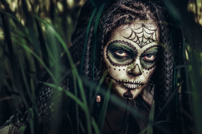 Woman with Sugar Skull face paint in jungle