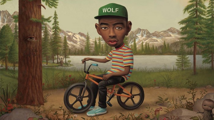 Tyler the Creator on a BMX bike in a forest landscape