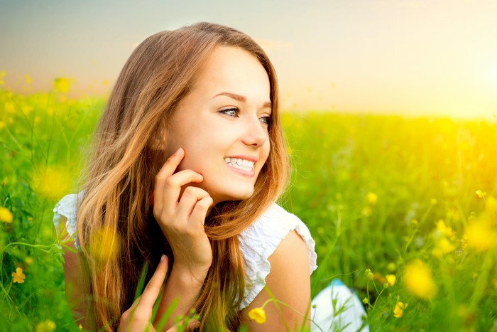 Woman smiling in a field of yellow flowers