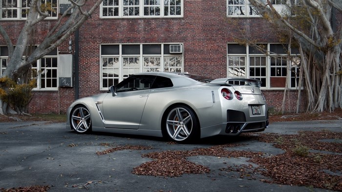 Silver Nissan GT-R R35 parked near brick building