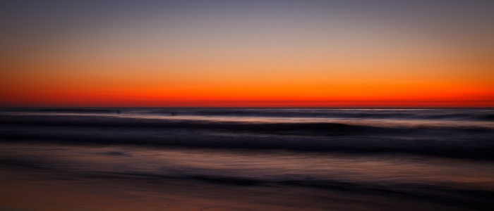 Sunset over the ocean with long exposure waves