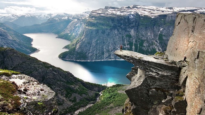 Man standing on Trolltunga rock overlooking Ringedalsvatnet lake, Norway