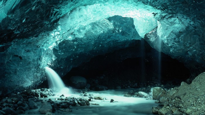 Ice cave with waterfall and stream