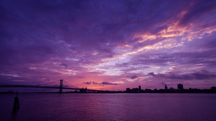 Bridge over water at sunset with purple sky