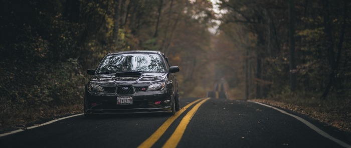 Black Subaru Impreza WRX STI on a forest road