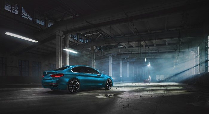 Blue BMW car in a dark industrial warehouse