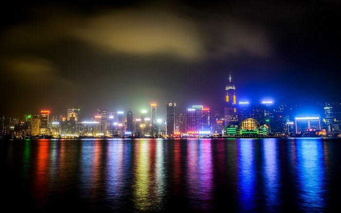 Hong Kong cityscape at night with colorful lights reflecting on water
