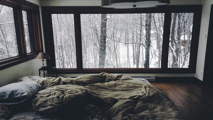 Cozy bedroom with a view of a snowy forest