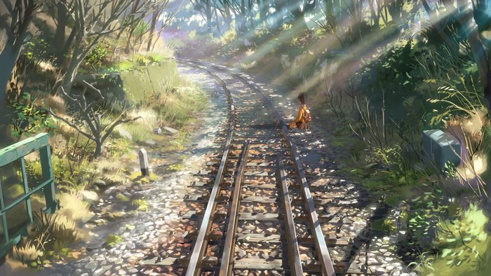 Girl sitting on train tracks in forest