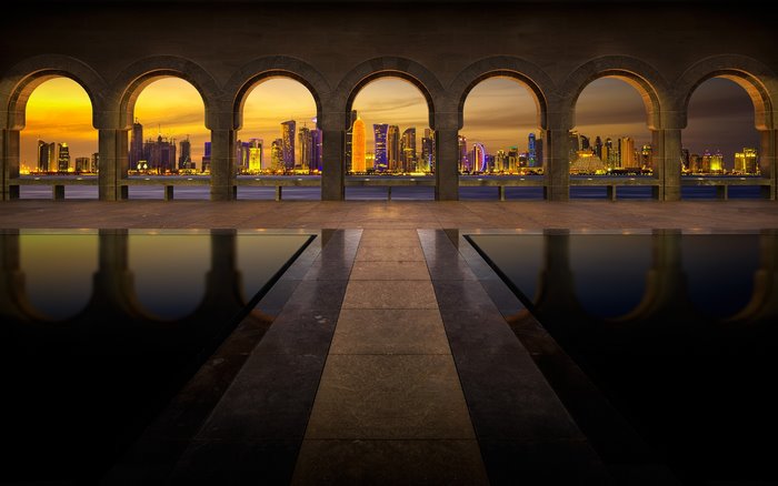 Doha cityscape viewed through arches with reflection