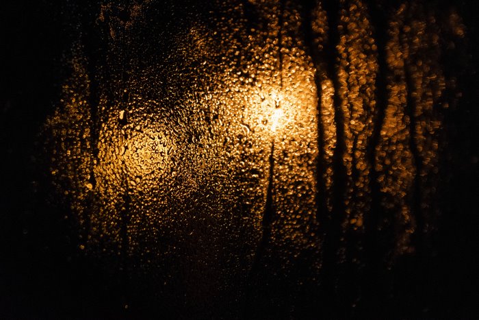 Raindrops on glass with orange light