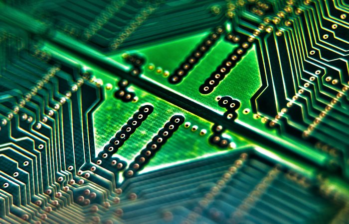 Macro view of a green circuit board with gold connectors