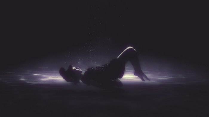 Woman underwater in dark water
