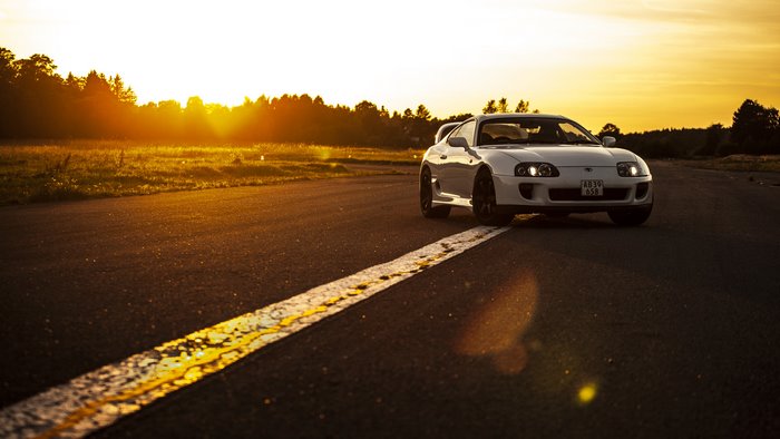 White Toyota Supra MKIV on asphalt road at sunset