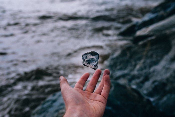 Hand levitating a rock over water