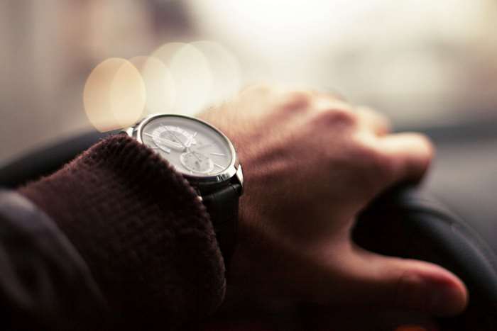 Man wearing a wristwatch driving a car