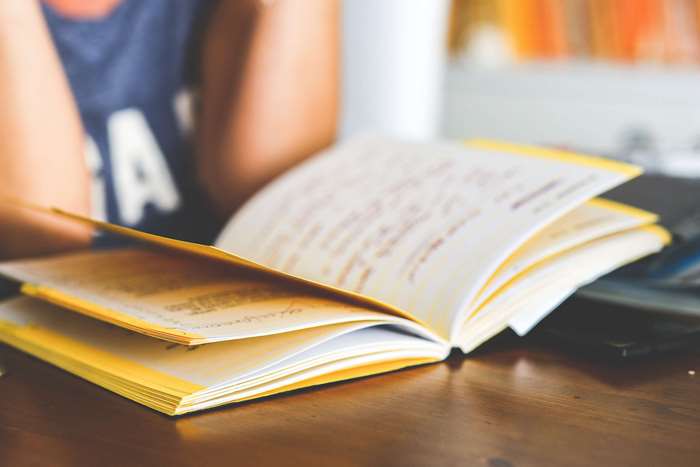 Open book with handwritten notes on a wooden table