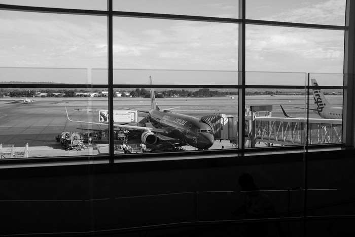 Airport tarmac with airplanes and jet bridge, black and white 4K