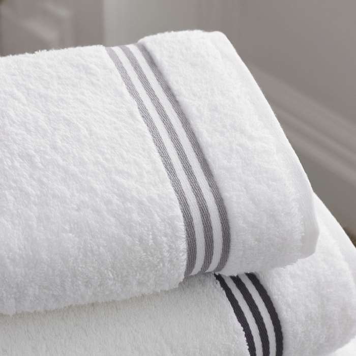 Stack of white bath towels with grey stripes