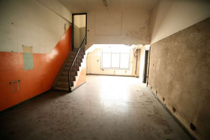 Abandoned building interior with staircase and window