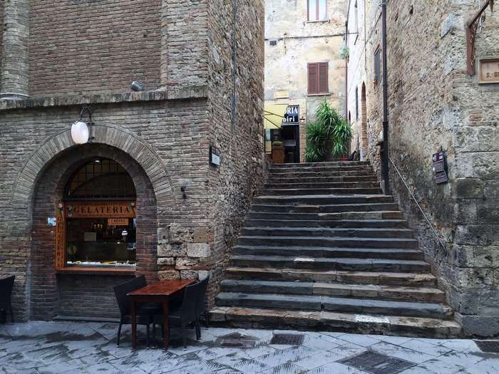 Gelateria with outdoor seating and stone stairs in Italy