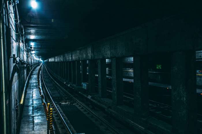 Dark 4K Underground Metro Tunnel with Rail Tracks