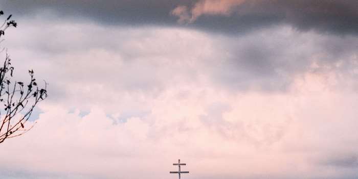 Cross against cloudy sky