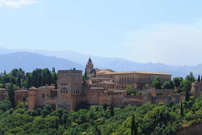 Alhambra castle in Granada, Spain with mountains and trees