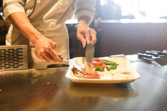 Chef plating shrimp and vegetables