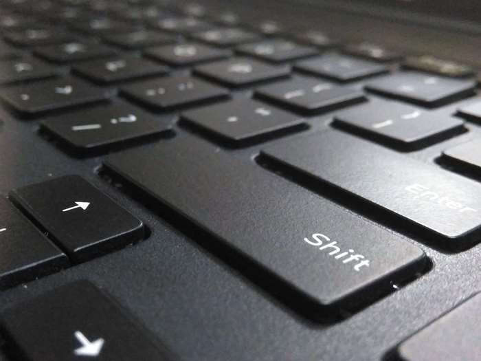 Close-up of a black laptop keyboard with Shift key