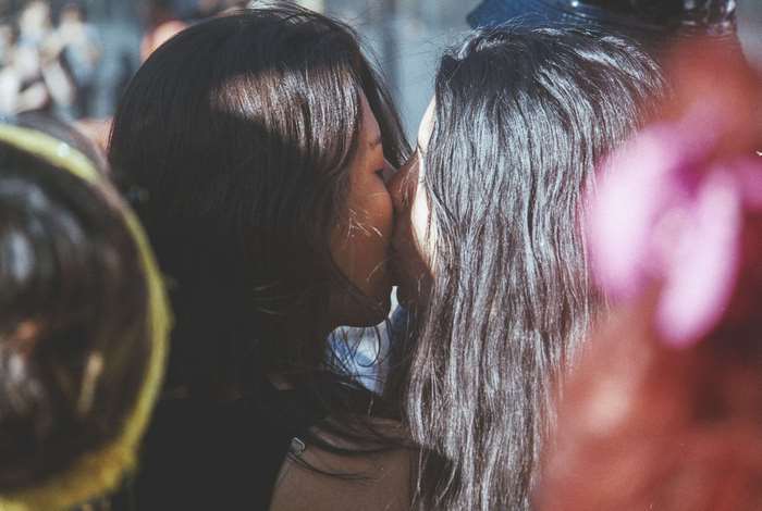 Two women kissing during a celebration