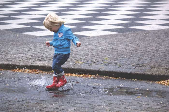 Child jumping in a puddle