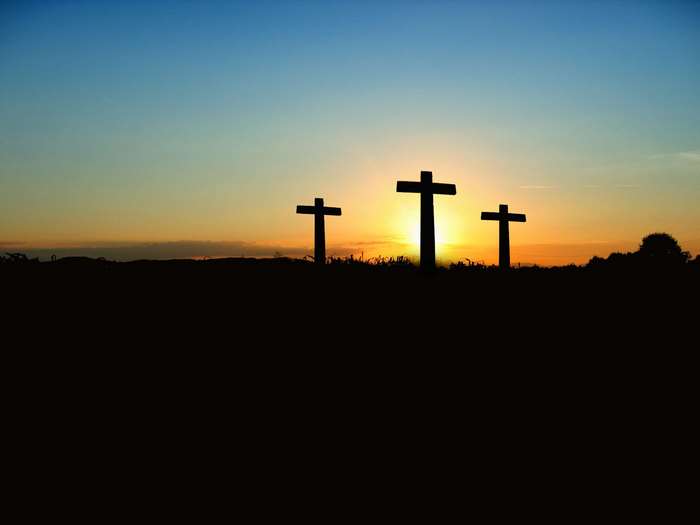 Three crosses silhouetted against a sunset sky