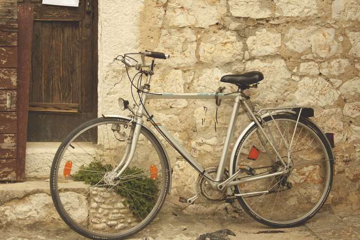 Vintage bicycle parked against a stone wall in an old town