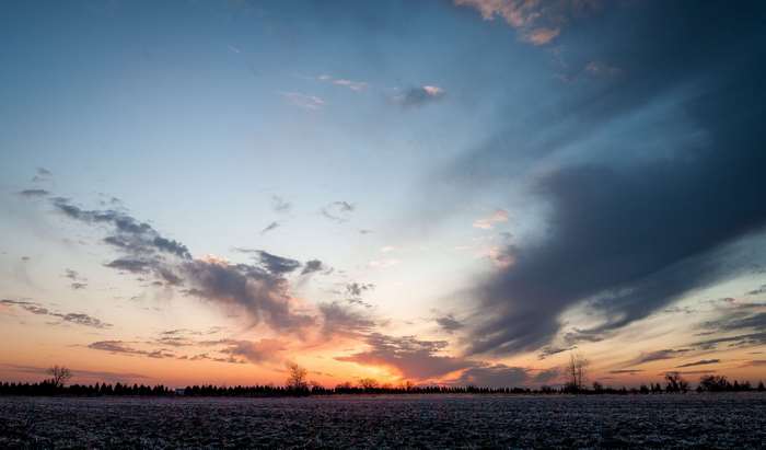 Sunset over a field with dramatic clouds 4K