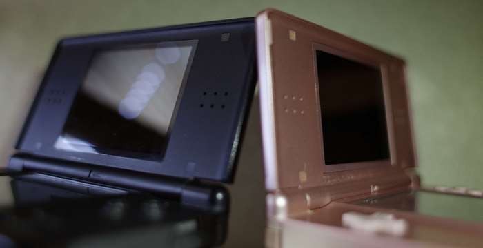 Two Nintendo DS consoles, one black and one rose gold
