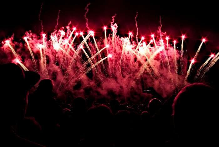 Crowd watching red fireworks at night 4K