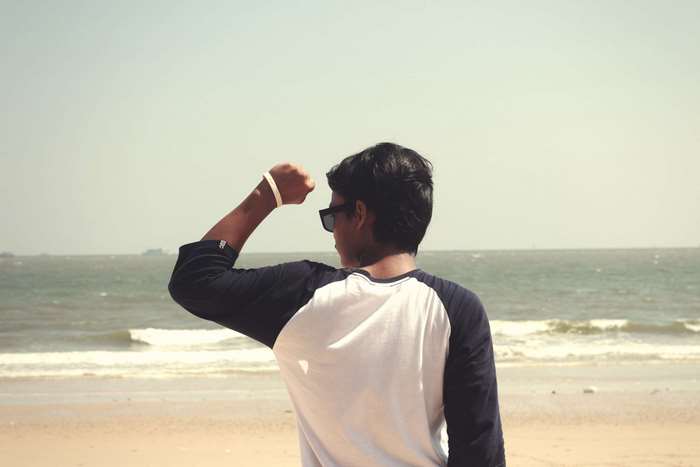 Man flexing on a beach 4K