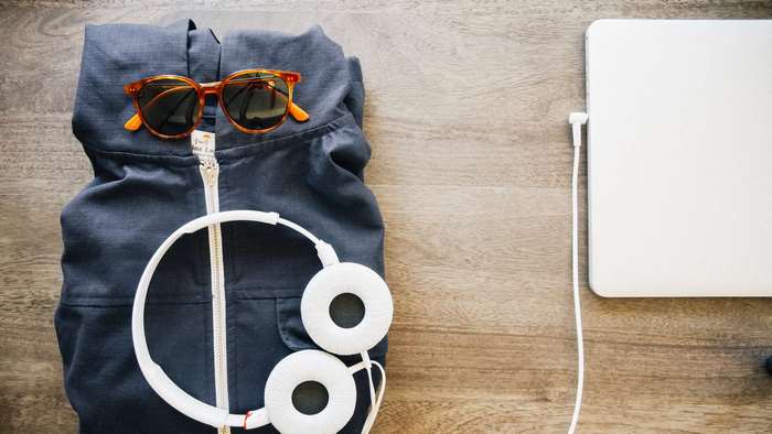 Folded jacket with sunglasses, headphones, and laptop