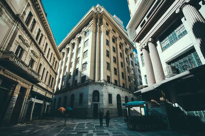 Couple walking in a city street between buildings 4K