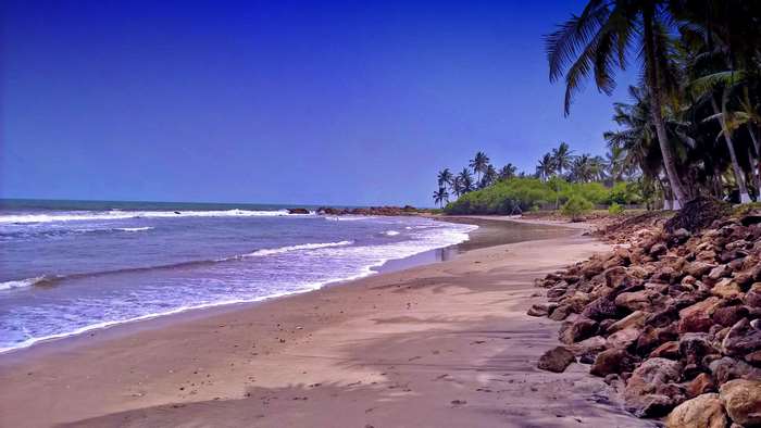 Beach with palm trees and ocean waves in Ghana