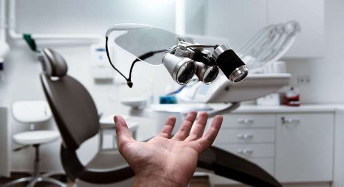 Dentist's loupes floating above a hand in a clinic
