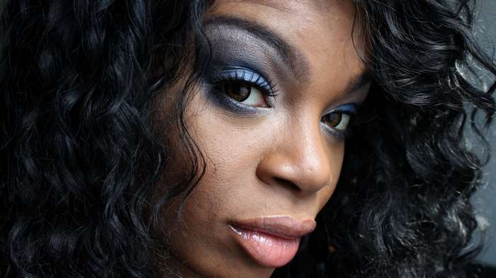 Close-up portrait of a Black woman with dramatic makeup