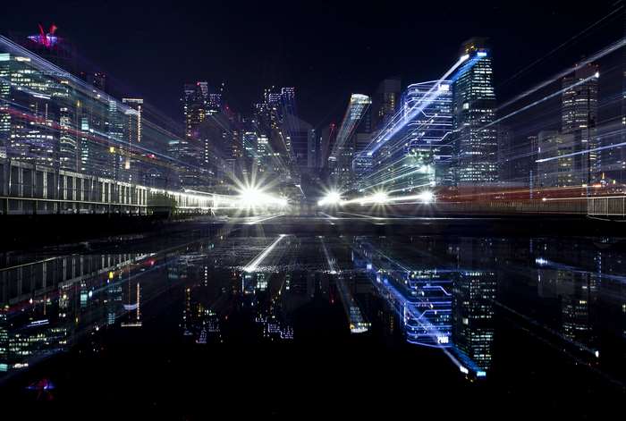 Cityscape at night with light trails and reflections