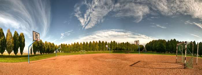 Panorama of a sports ground with basketball and football goals