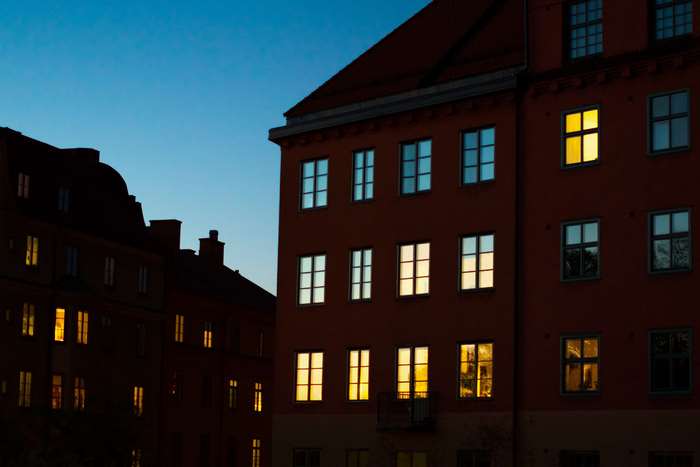 Apartment buildings at dusk with illuminated windows